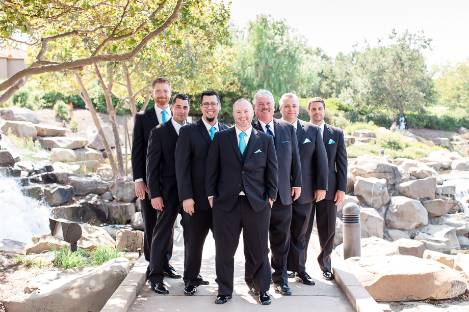 groom with groomsmen group photo in front of a waterfall