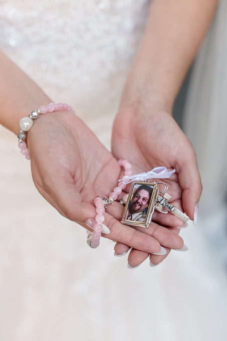 bride holds this rosary that has her fathers picture for the entire ceremony