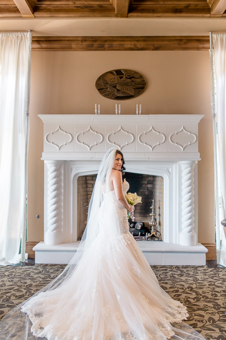 stunning bridal portrait in front of a fireplace at the Bridges Golf Club
