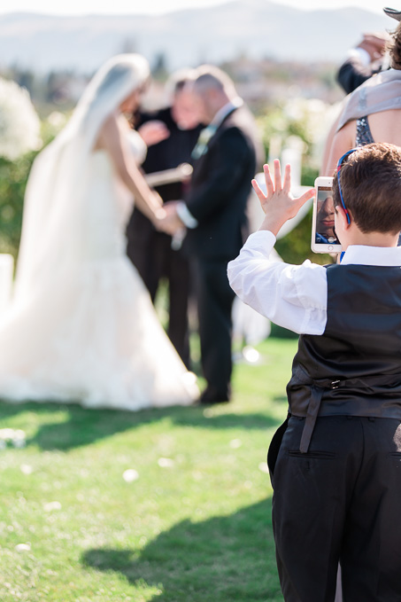 a kid giving blessings to the bride and groom while taking a selfie