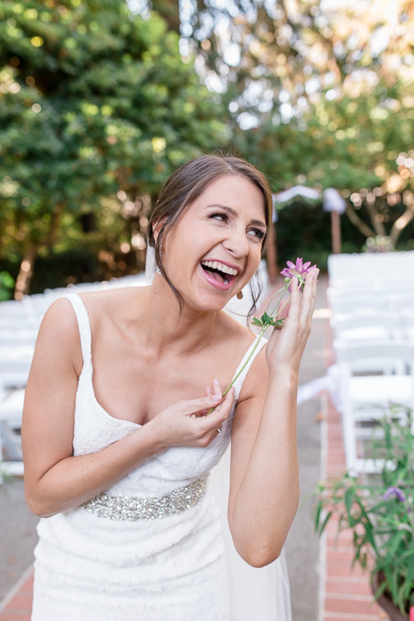 a fun photo of bride posing with a dainty little flower