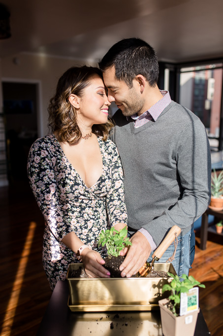 couple have their engagement photos taken at their San Francisco downtown apartment planting together