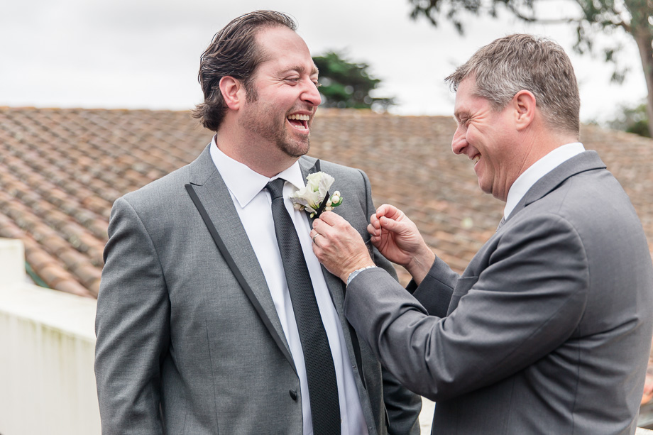 best man pinning boutonniere for the groom