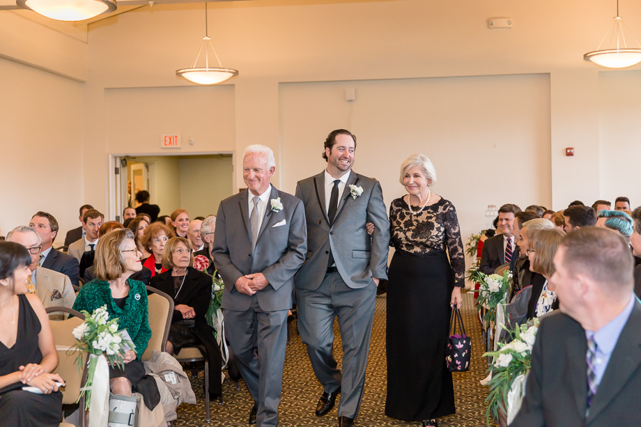 groom walking down the aisle with his parents