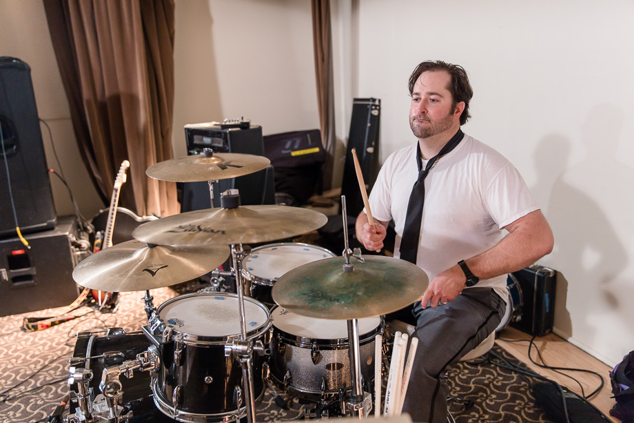 groom plays the drum at his wedding reception