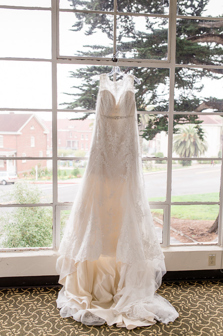 A-line lace wedding gown hanging on the window