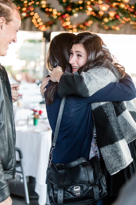 hugging her family who witnessed the proposal from a nearby restaurant