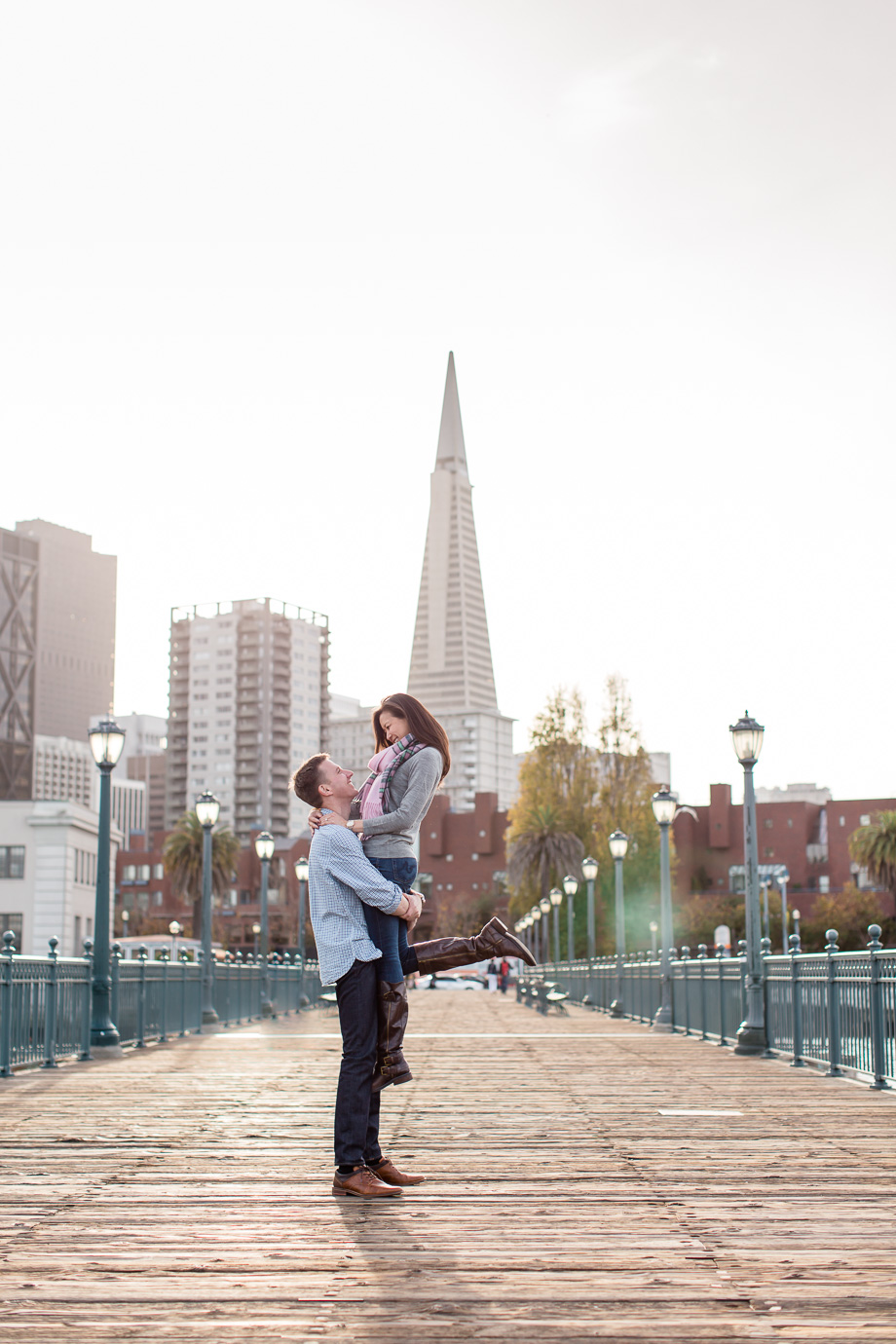 romantic engagement photo at san francisco pier overlooking financial district skyline