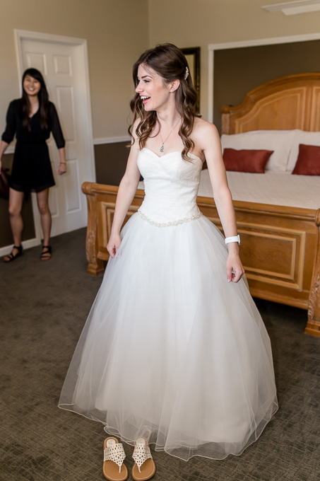 bride getting into her tulle wedding gown