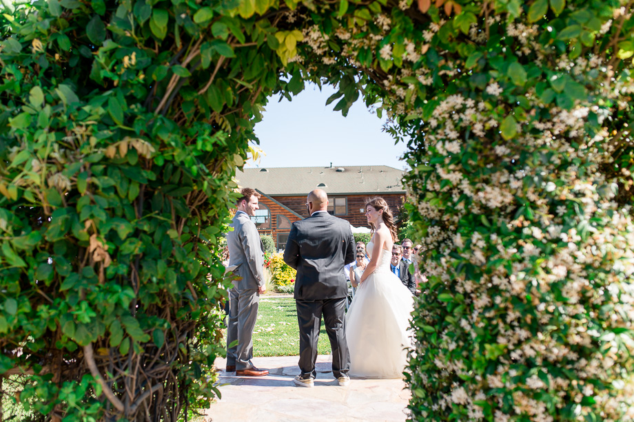 wedding ceremony under flower arch