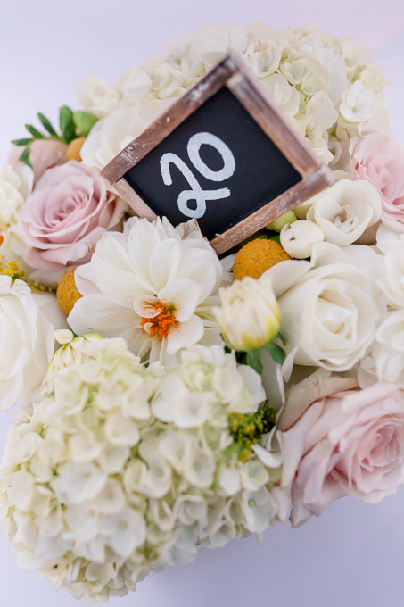 pink and white floral centerpiece with a rustic chalkboard table number - california outdoor wedding