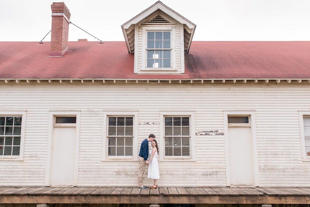 engaged couple in front of a rustic building