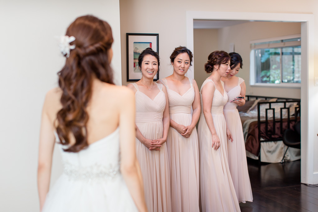 adorable bridesmaids looking at the beautiful bride