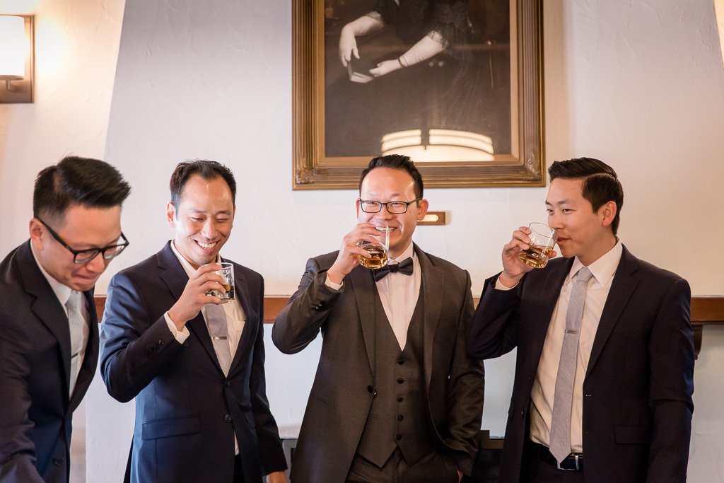 groom and groomsmen drinking round of whiskey before wedding