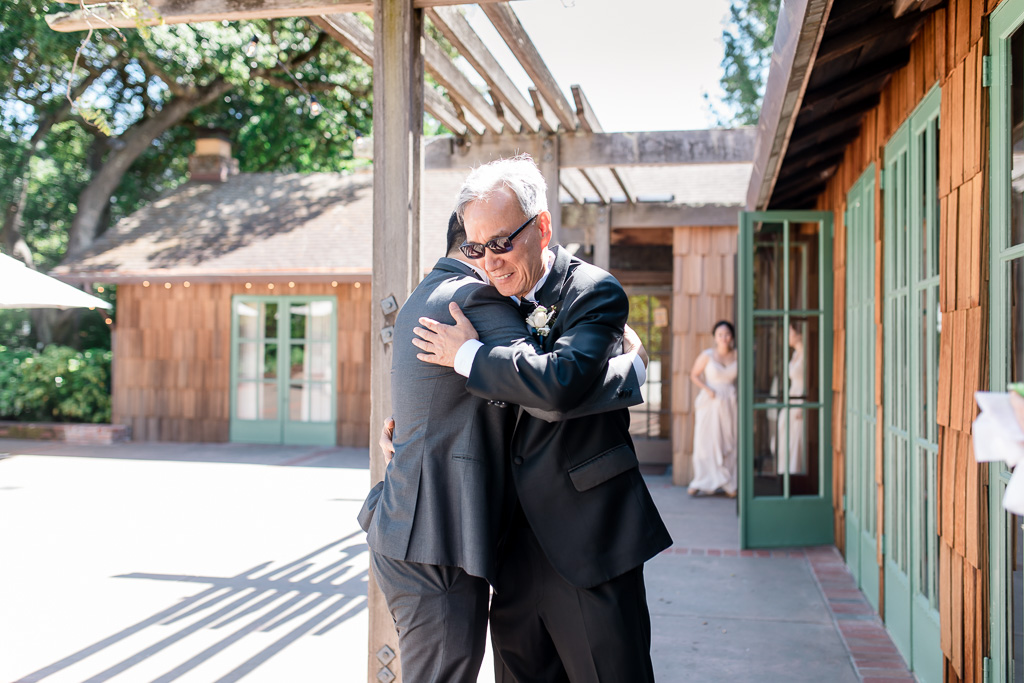 groom giving the father of the bride a hug