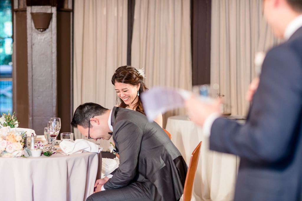 bride and groom laughing hysterically during best man's funny wedding toast
