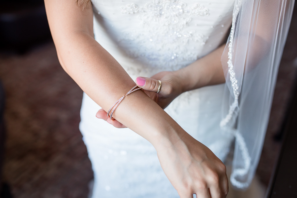 bride putting on bracelet