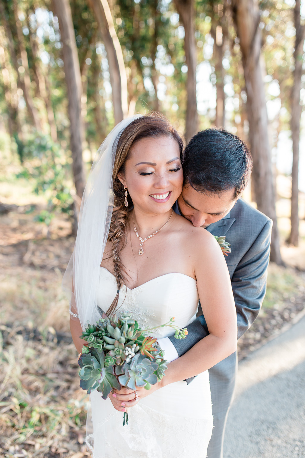 photo of groom and bride holding floral DIY bouquet in the woods