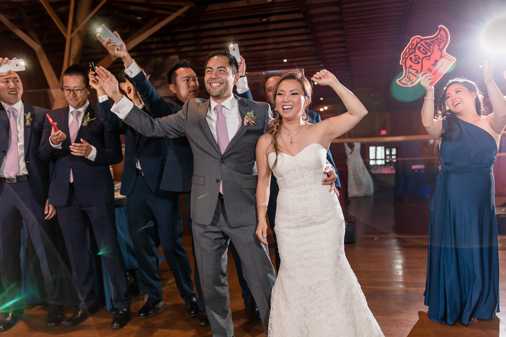 bride and groom dancing welcomed by bridal party waving cell phone flashlights