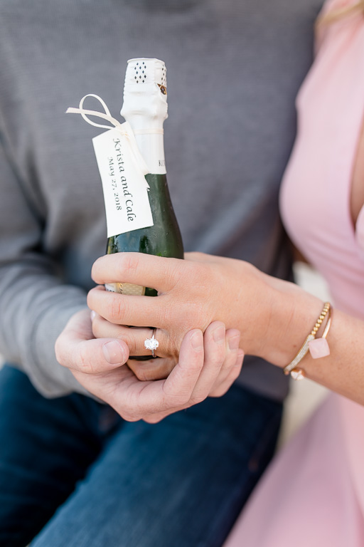 champagne bottle and engagement ring