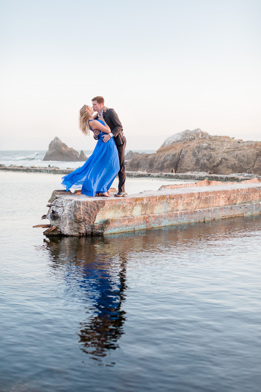 Sutro Baths reflection engagement photo of couple dipping and kissing