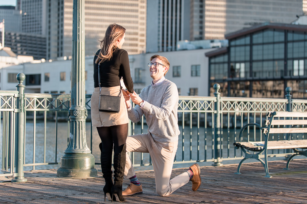 very happy groom-to-be proposing to his future bride at Pier 7 Embarcadero San Francisco
