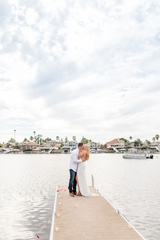 engagement photo at end of dock on a beautiful lake under the sun