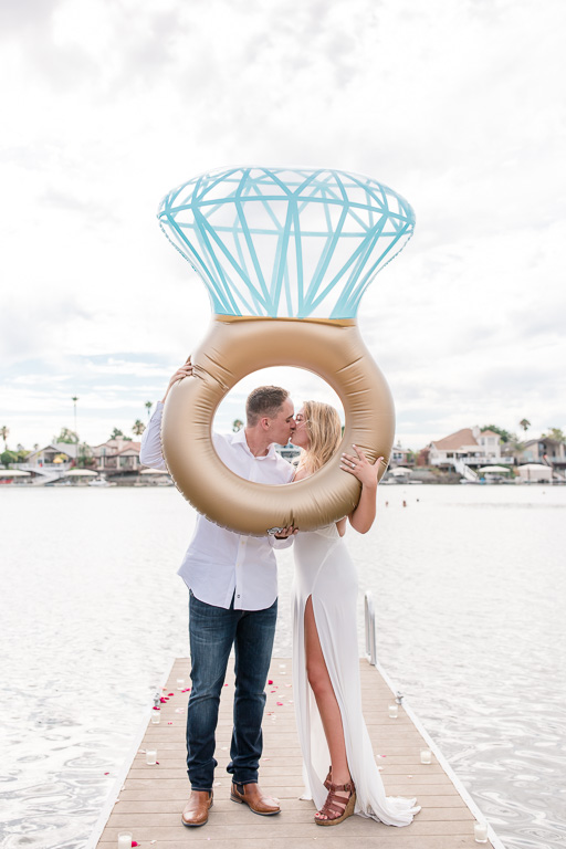 couple kissing inside a huge funny cute diamond ring floatation device