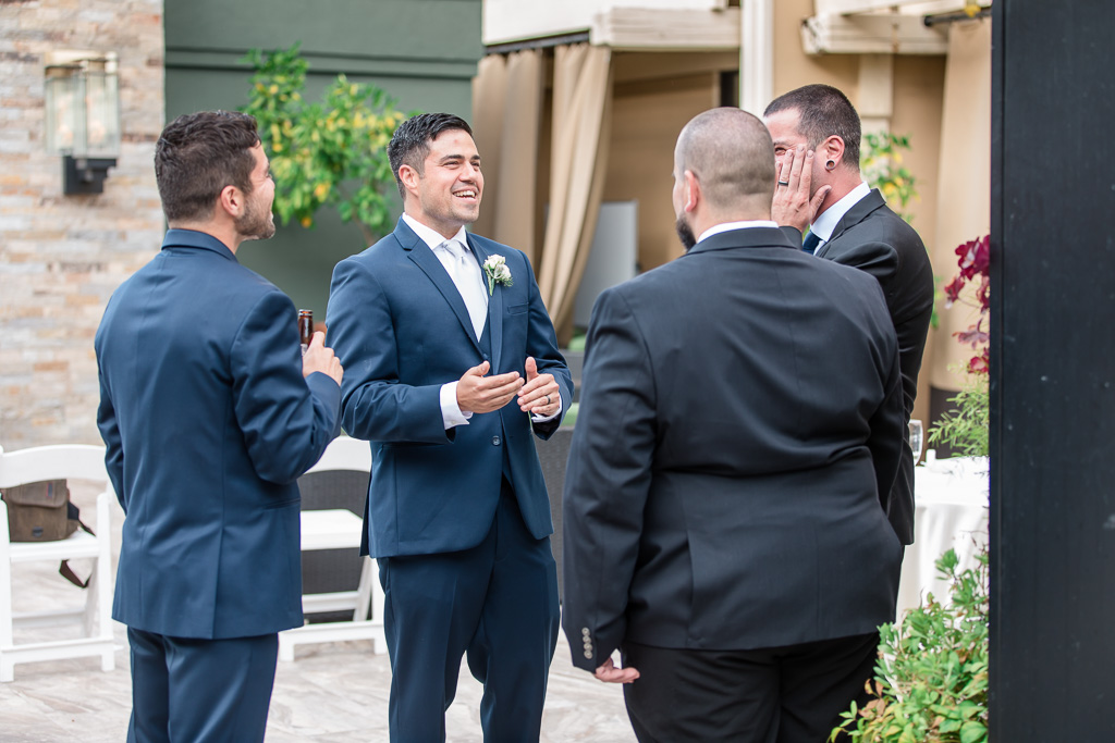 groom chatting with friends during cocktail hour