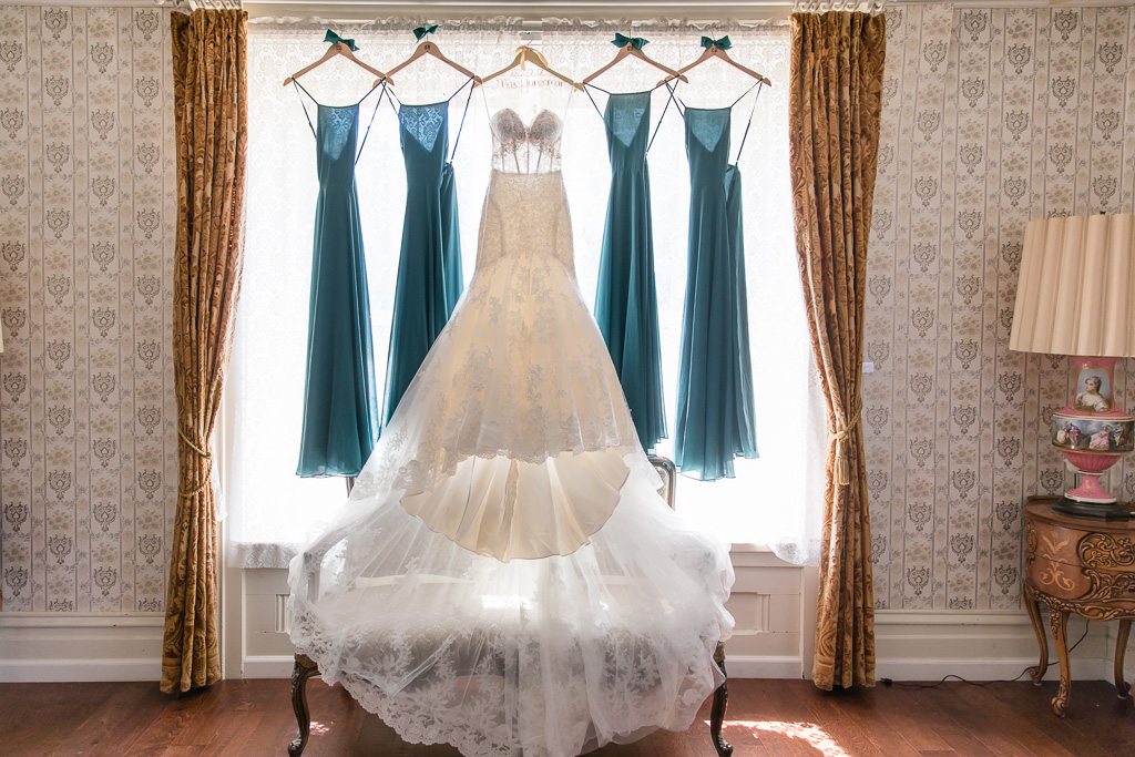 stunning see through wedding gown hanging on a floor length window