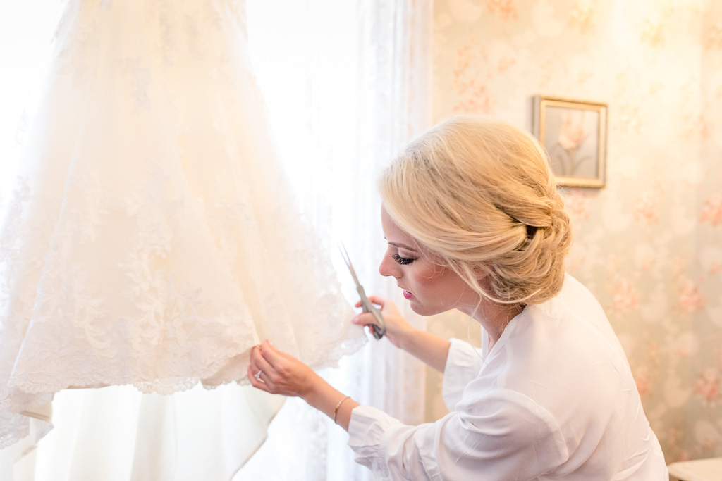 bride adding final details to her wedding dress