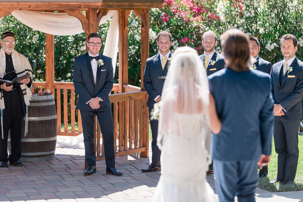 groom is so happy to see his bride walking down the aisle