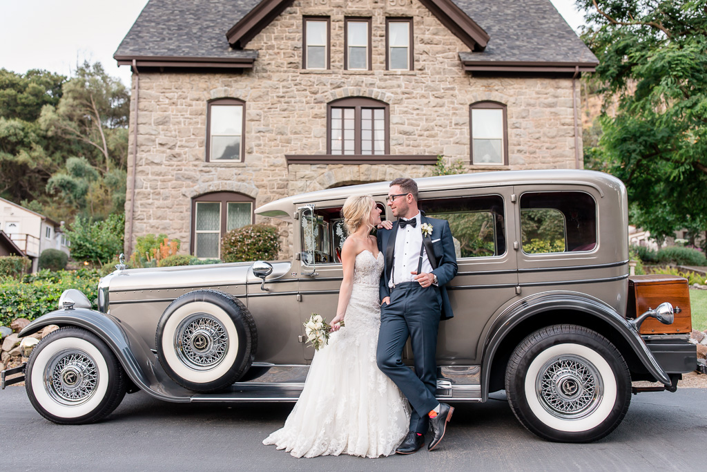 newlyweds with their classic car in front of the elliston mansion