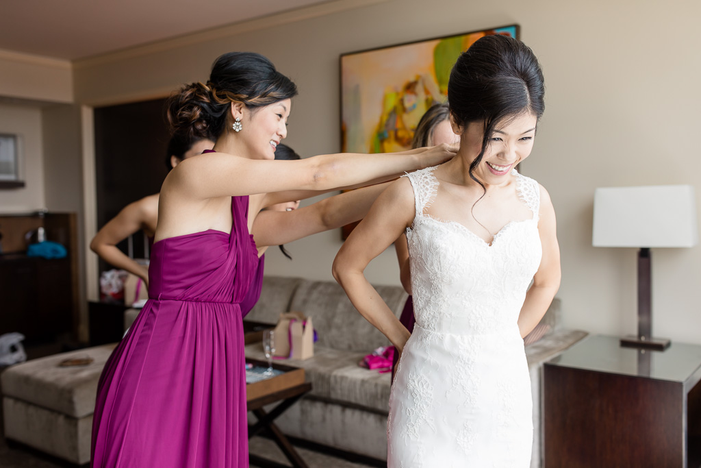zipping up the wedding dress