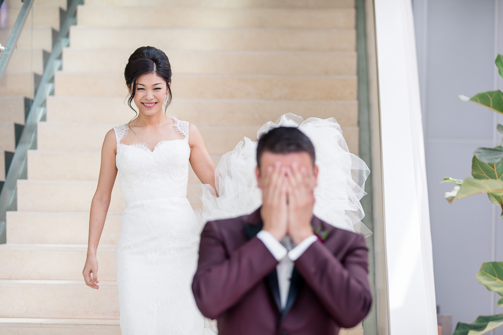 bride walking down hotel staircase for their first look