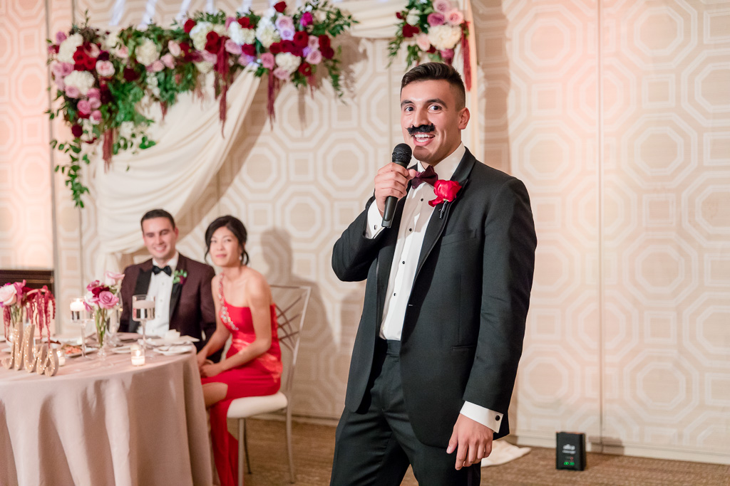 best man with a fake mustache giving a toast