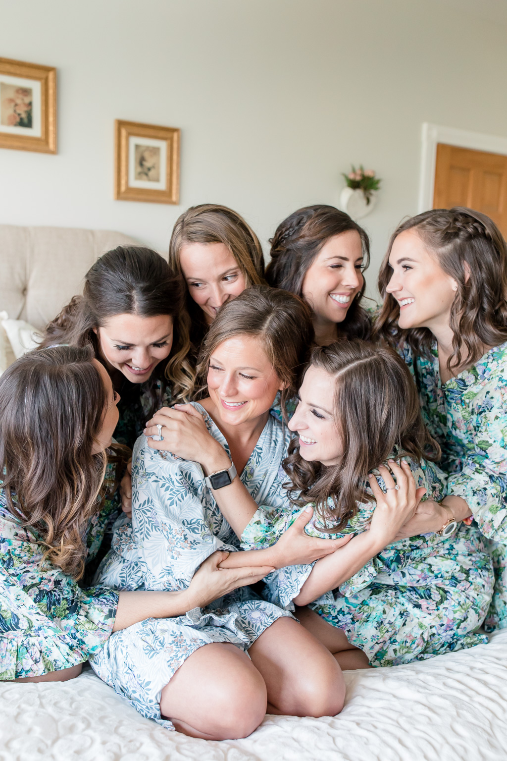 bridesmaids group hugging the beautiful bride in their matching robes