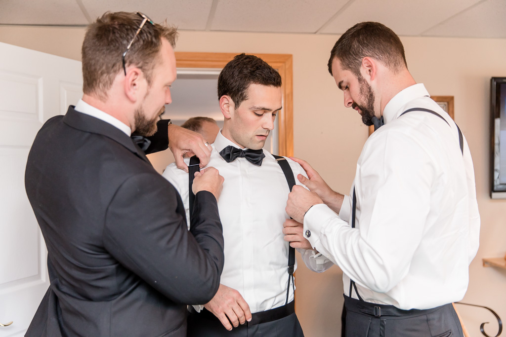 groomsmen helping the groom get ready