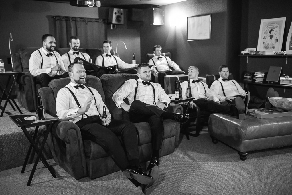groom and groomsmen chilling at the theater room at the highlands estate