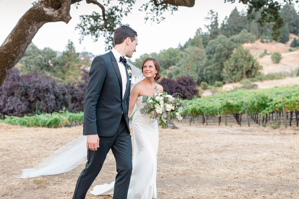 newlyweds walking along the vineyards