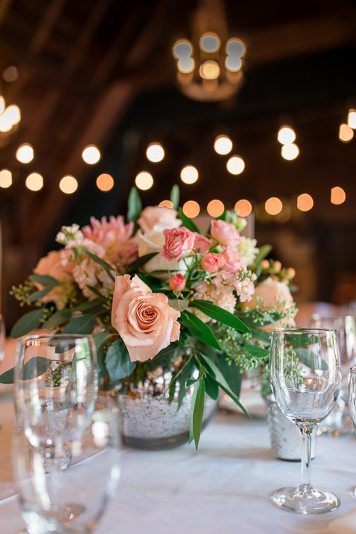 floral centerpiece with bistro lights in the background