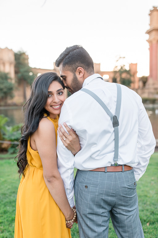 engagement photo wearing vibrant yellow dress and looking back at camera