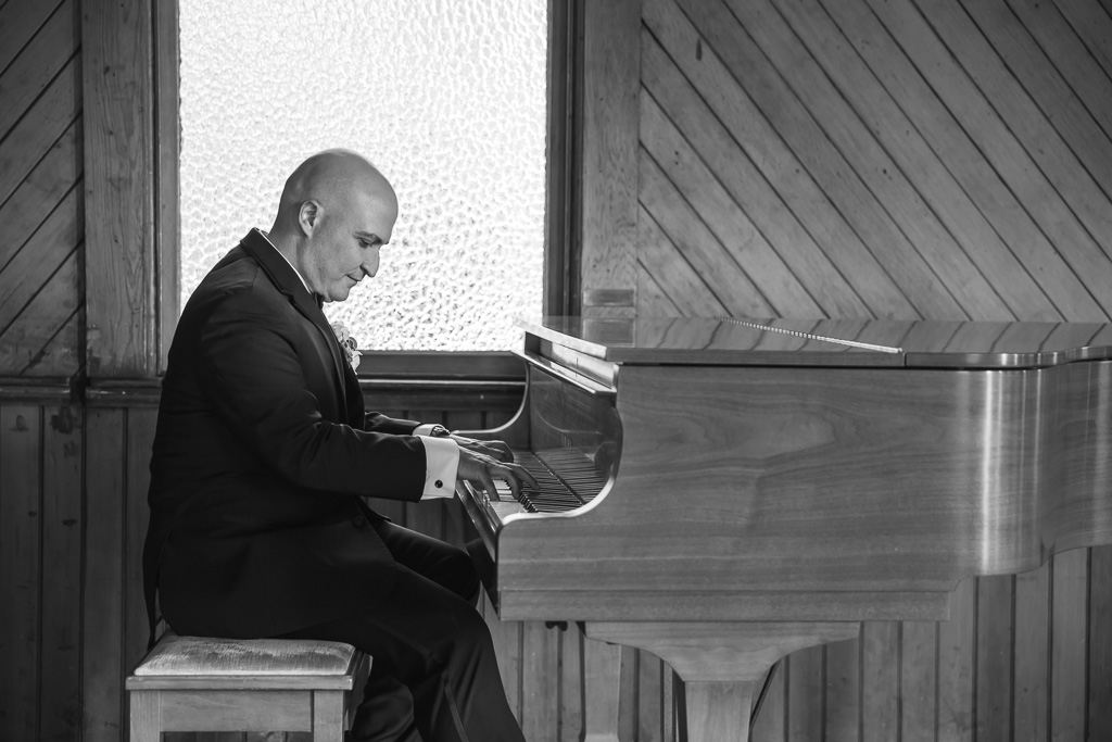 groom playing piano at the church