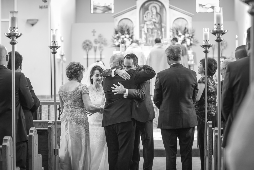 newlyweds hugging their parents before walking down the aisle as husband and wife