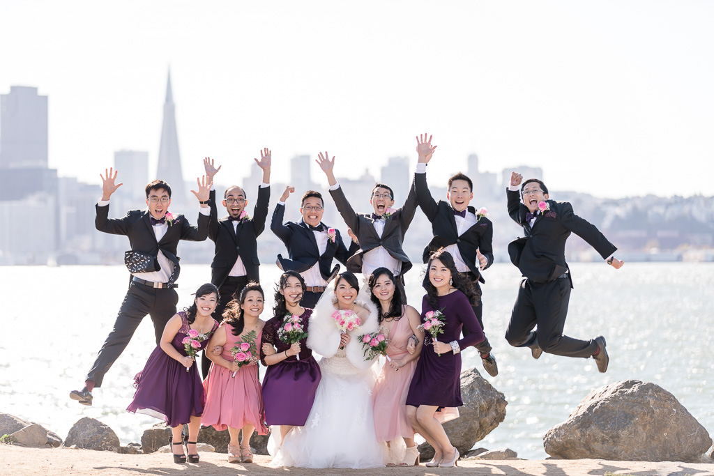 fun and creative wedding party photo with a stunning view of the san francisco skyline