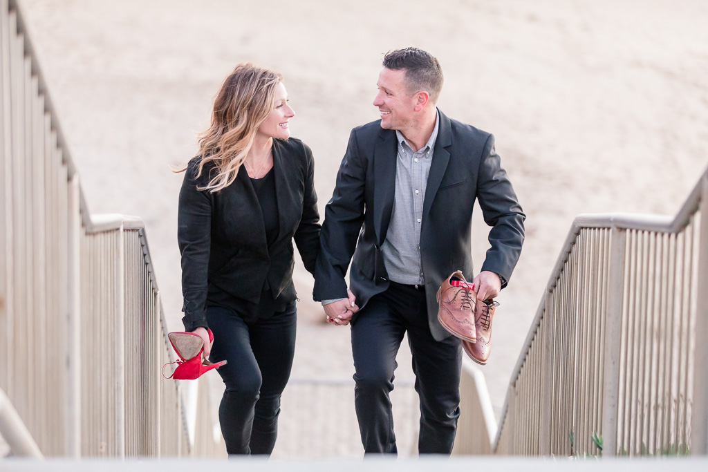 cute couple walking up steps from beach