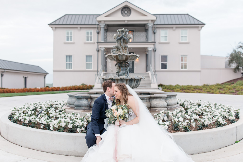 bride and groom portraits at the fountain in front of the willow heights mansion
