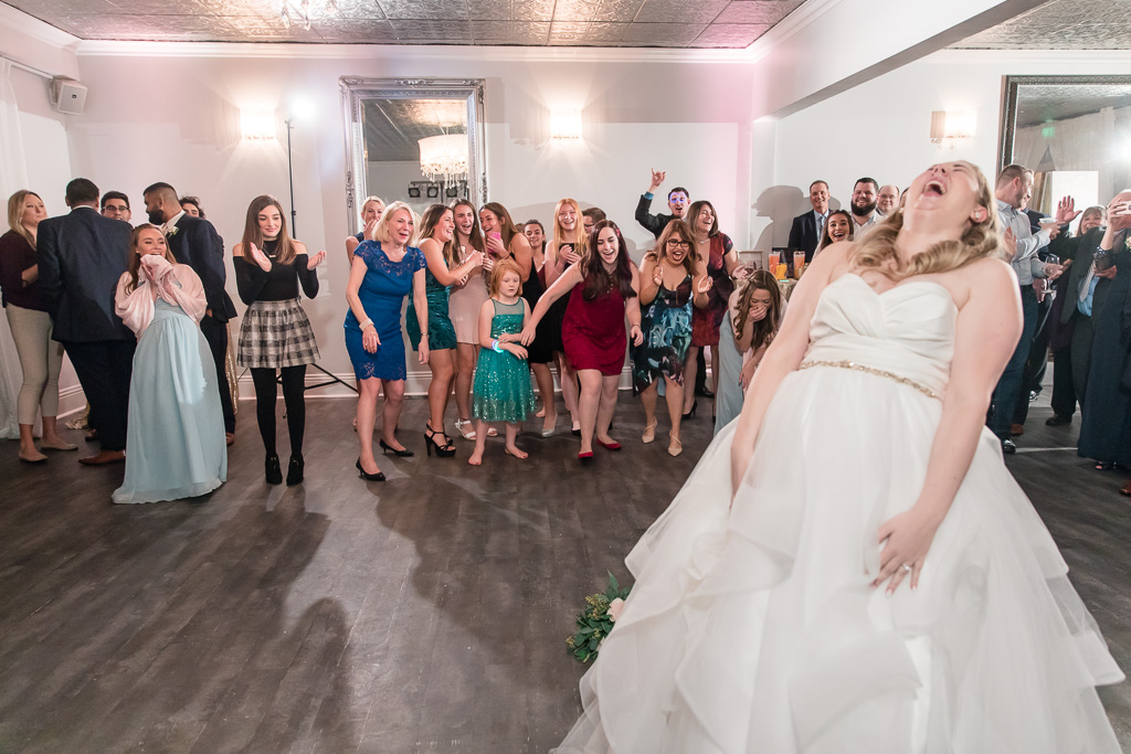 bride laughing so hard at the bouquet toss