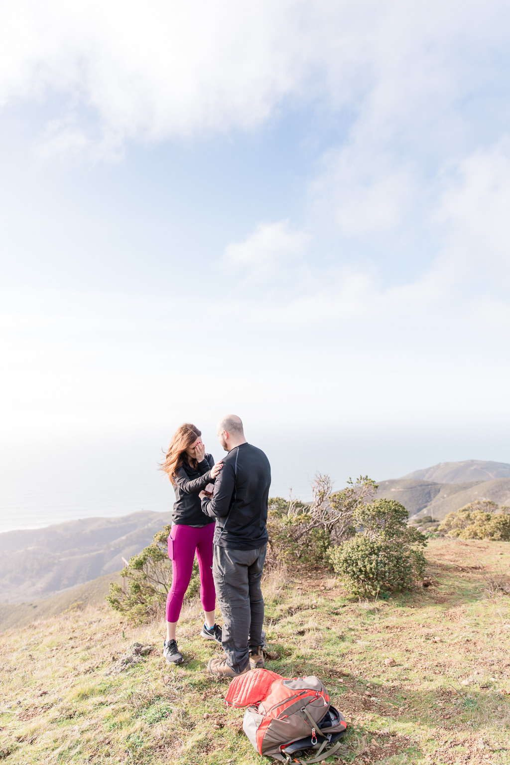 Surprise engagement captured by professional photographers on top of the mountains