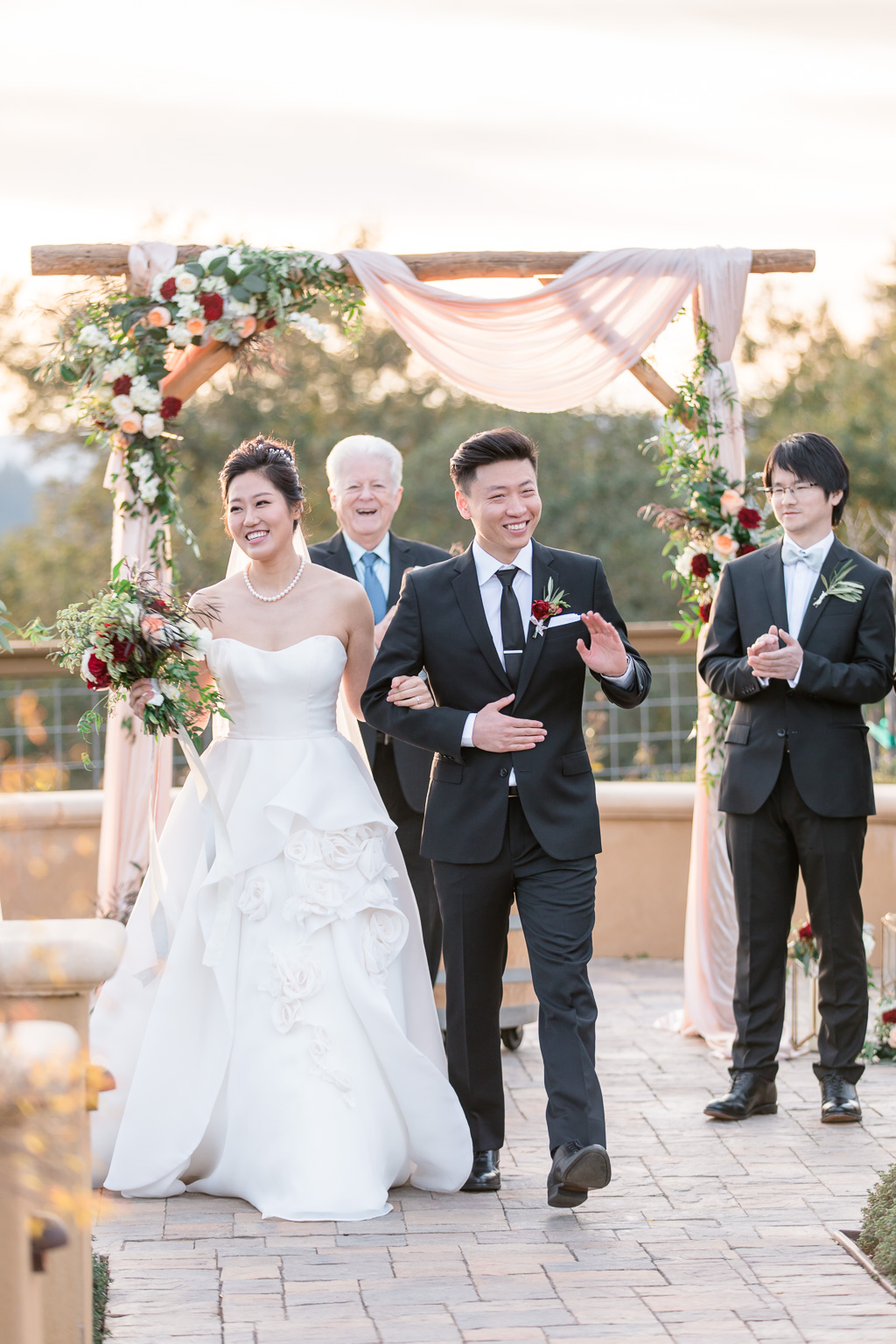 waving at their guests at the end of the ceremony